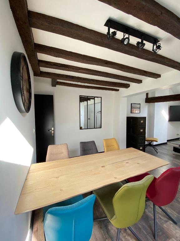 Salle à manger avec une table en bois et des chaises colorées