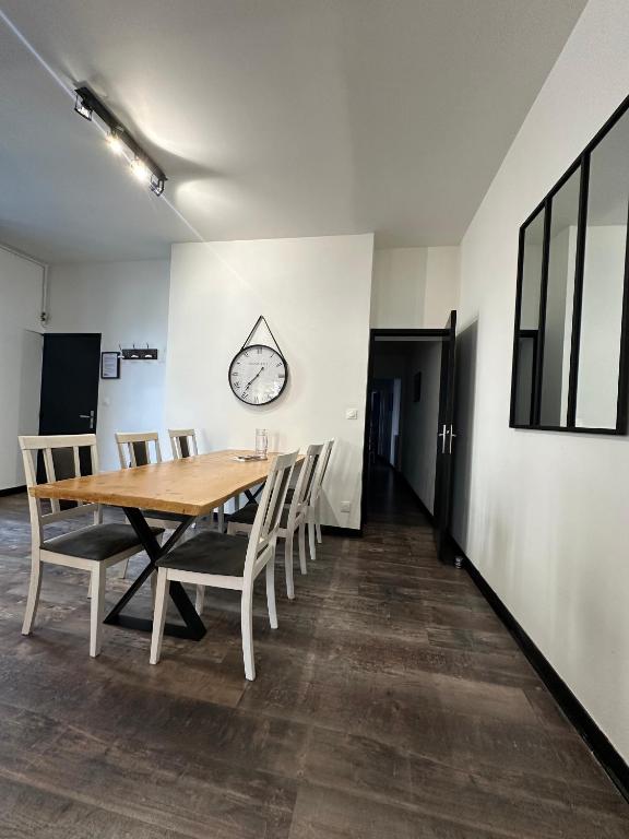 Salle à manger avec une table en bois et des chaises blanches et noires