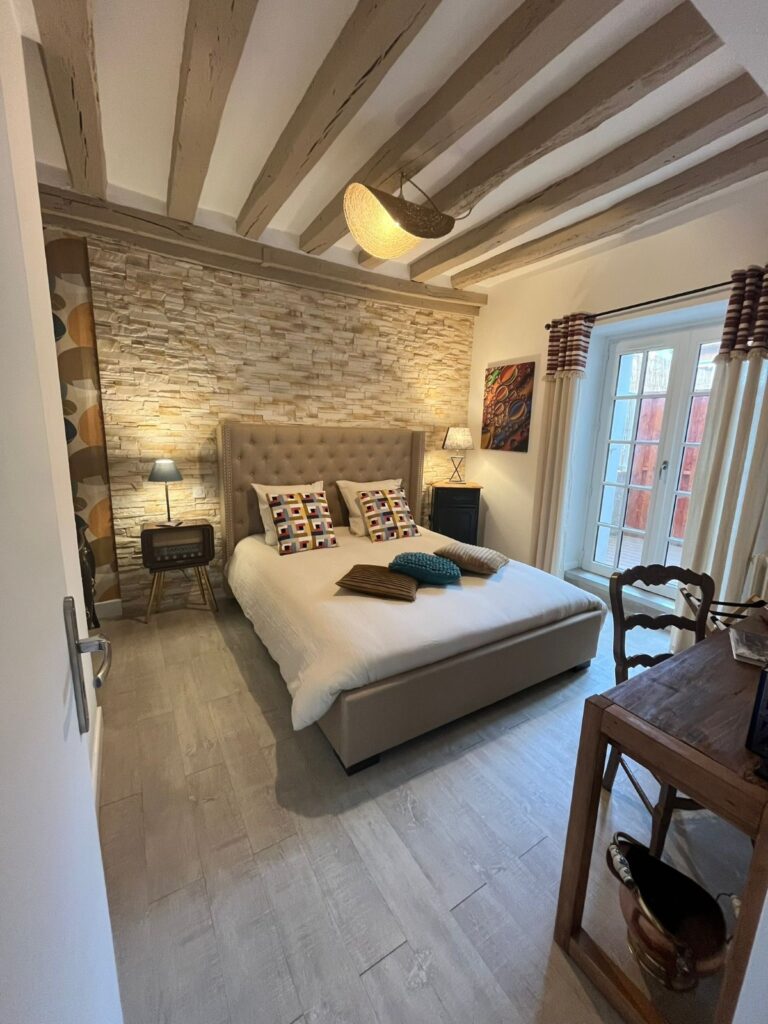 Chambre beige avec lit double et bureau